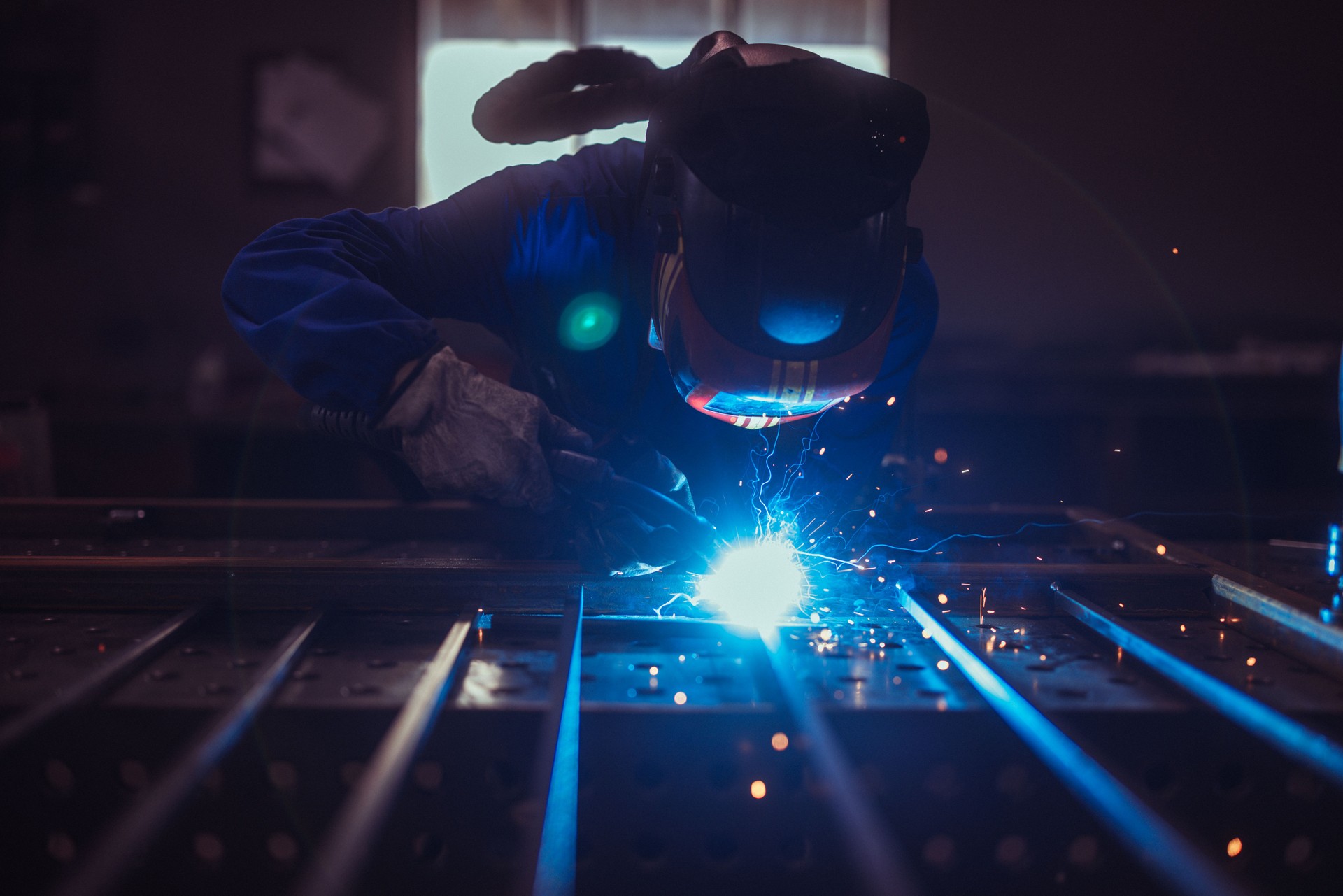 Welder at Work Creating Sparks in Workshop